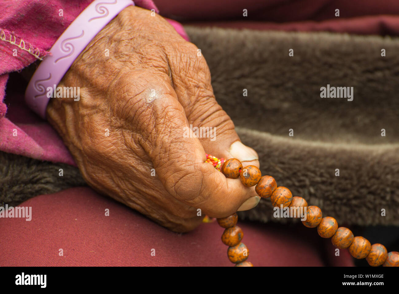 buddhist monch praying with his prayer beads mala consisting of 108 beads representing the 108 volumes of buddhas lessons nar on the na | Phuc Linh Agarwood